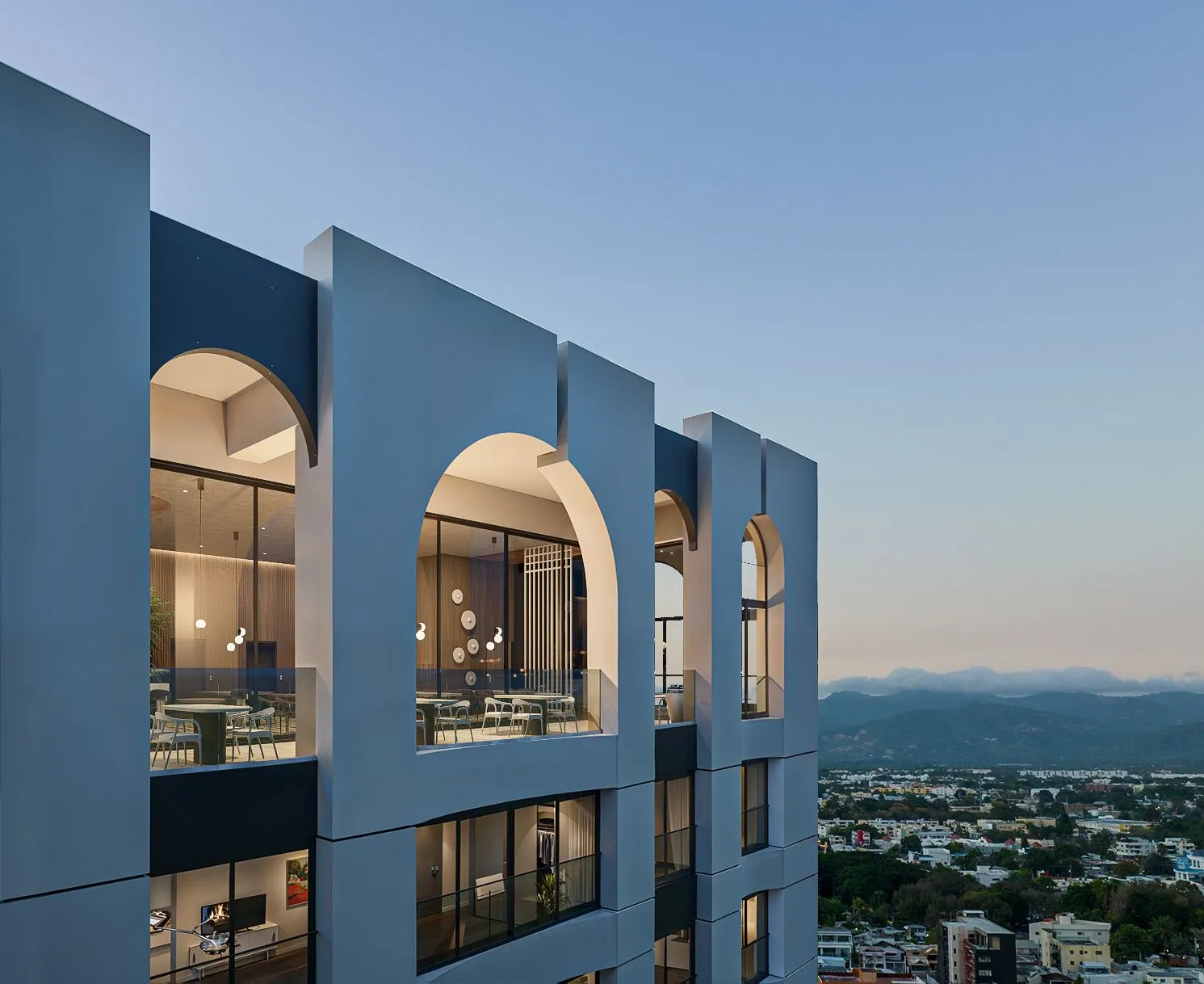 Arcos de la fachada de 031 Condo al atardecer, inspirados en el Santiago histórico