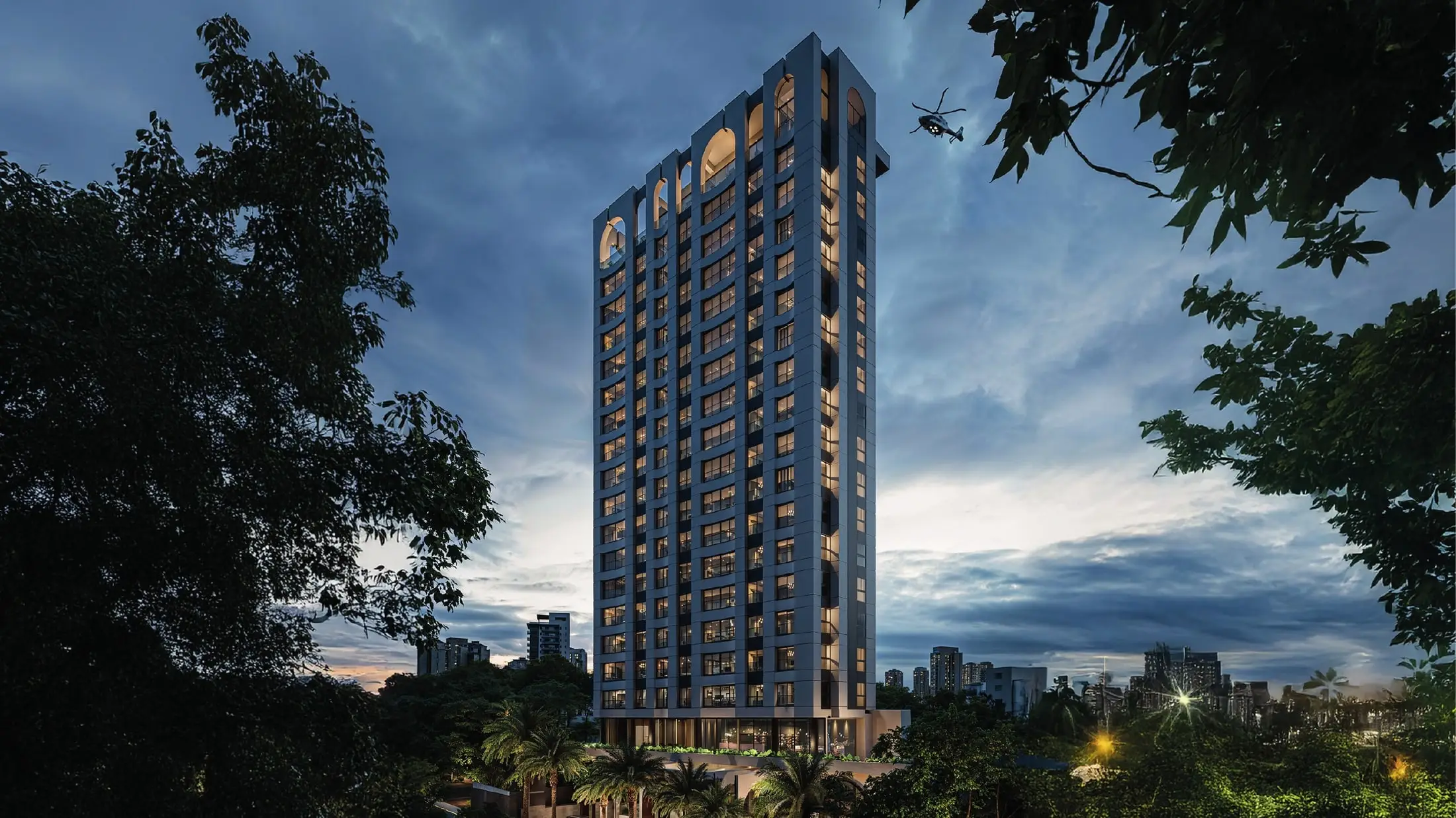 Torre de 23 niveles de 031 Condo iluminada al anochecer entre la vegetación de Reparto Panorama